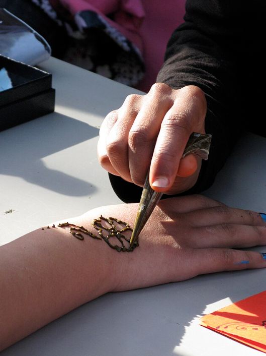 Applying henna to a hand